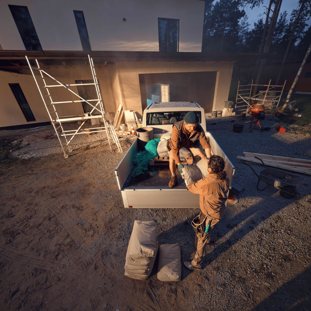 VW Transporter Pritsche auf Baustelle mit zwei Personen